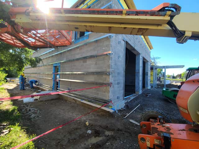 The exterior wall of a commercial building being insulated with spray foam