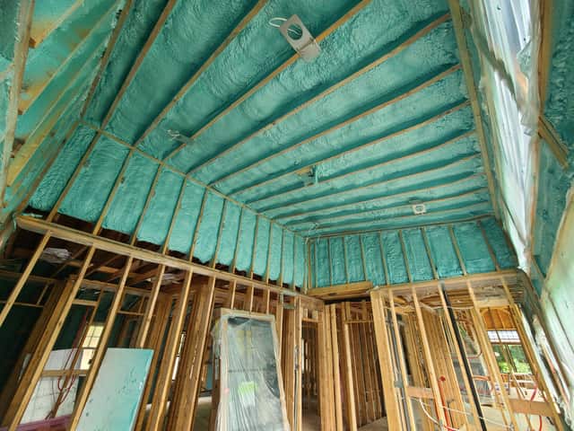 Spray foam applied between roof rafters, sealing the underside of the roof deck